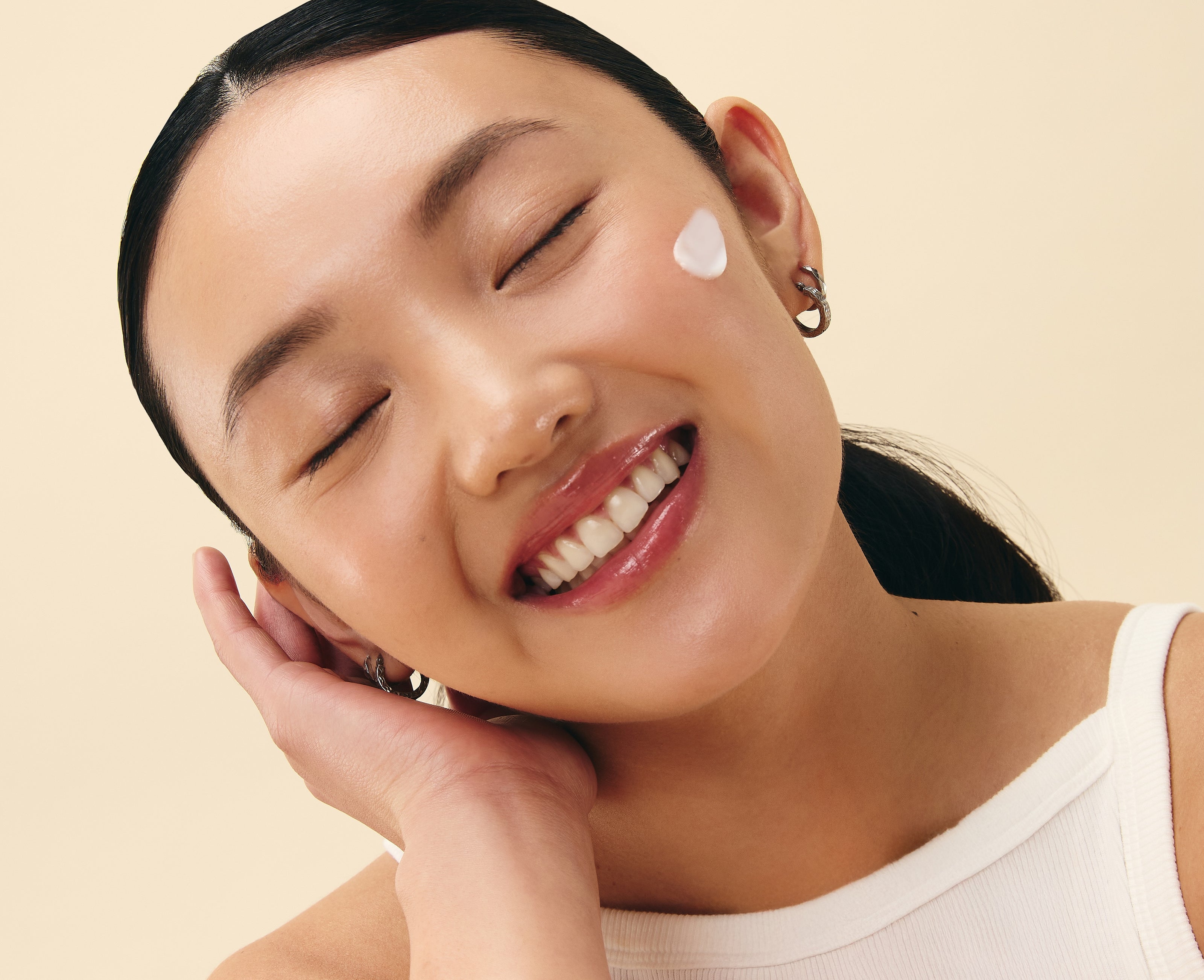 smiling woman applying soothing skincare for redness with anti inflammatory korean skincare for eczema-prone skin